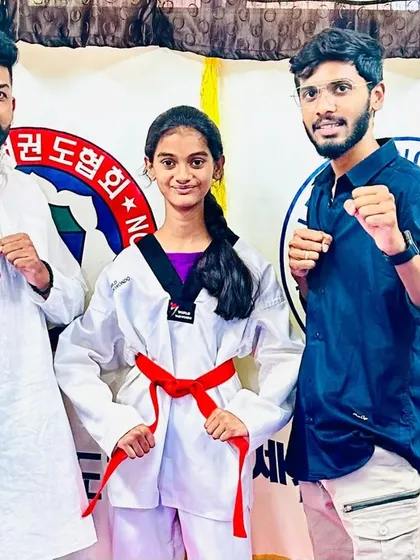 A young lady celebrates her new red belt.