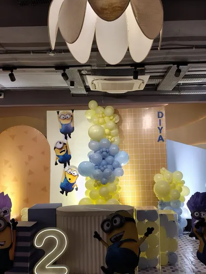 Bello! This Minions-themed second birthday party is full of playful trouble. The setup features character cutouts, a custom "DIYA" name display, and a fun blue and yellow balloon arrangement to capture the energetic spirit of the Minions.