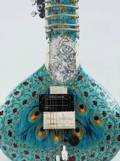A close up of one of our most detailed custom pieces, the peacock design sitar. This is an electric sitar, or Zitar, featuring intricate artwork and a Seymour Duncan pickup for a powerful, clear studio sound.