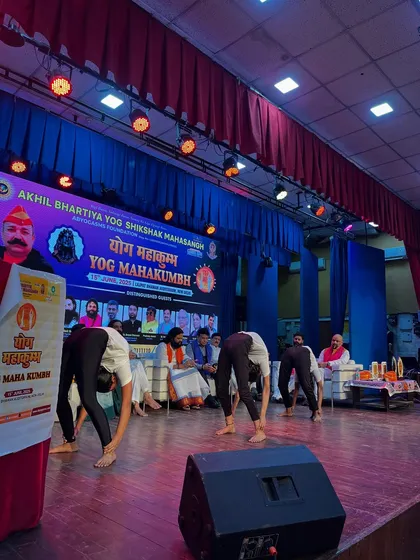 My team performing a synchronized forward fold, a demonstration of flexibility and discipline in front of a live audience.