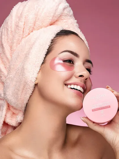This lifestyle beauty shot captures a moment of joyful self-care. The model's genuine smile, combined with the practical application of the under-eye patches, creates a relatable and aspirational image. It’s perfect for brands wanting to connect with their audience on a personal, authentic level.