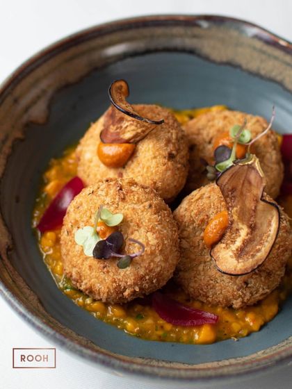 A detailed view of the Cheese and Yogurt Cutlet, showing the golden-brown crust and the colourful garnishes that make the dish pop.
