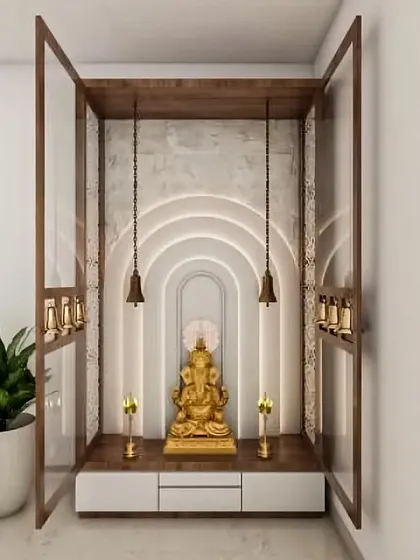 I create serene pooja spaces that blend modern design with traditional reverence. This unit uses backlit arches and hanging bells to create a peaceful focal point, complete with drawers for storing essentials.