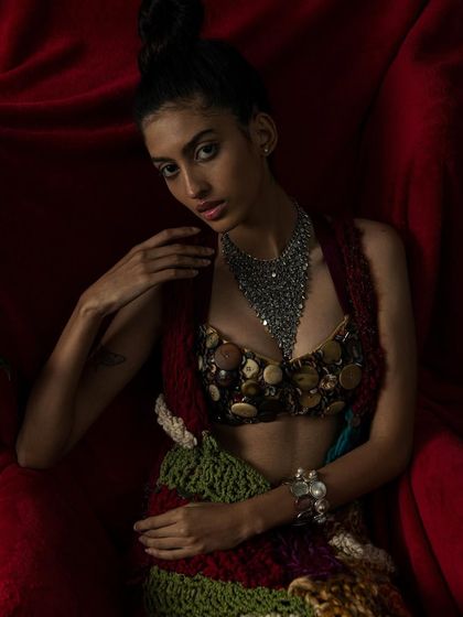 A close-up that draws the viewer in, focusing on the model's expression and the statement necklace.