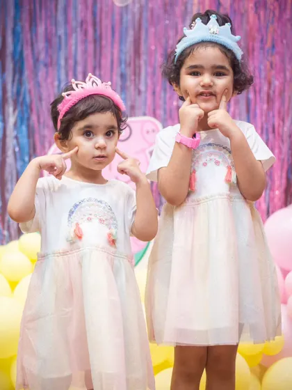 Two adorable sisters posing in their matching dresses. These are the sweet moments to cherish.