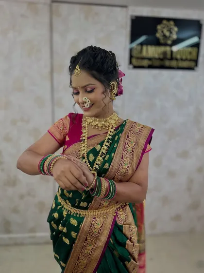 A candid shot of the model during a makeup demonstration, showing the full traditional attire and makeup.
