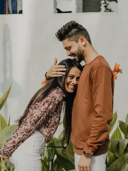 A sweet and playful moment where she leans into his embrace. This candid outdoor portrait is full of warmth and genuine affection.