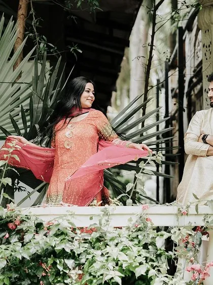 A romantic pose on a balcony surrounded by greenery, part of our charming architectural sets.