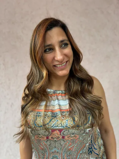 A happy client showing off her corrected and freshly colored brunette hair. The new color is vibrant, healthy, and perfectly suits her.