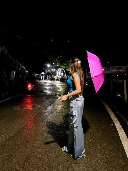 A night shot on a wet mountain road. The reflection of the lights on the street creates a beautiful, moody effect.