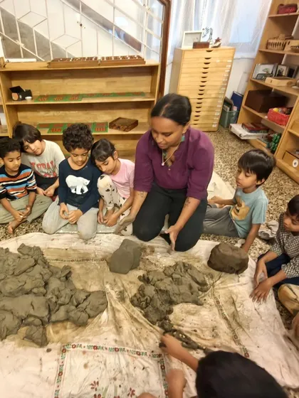 Children sit in a circle, learning to process clay that they harvested themselves from a local lake. Working with this elemental material connects them to the earth and provides a medium for three-dimensional expression.
