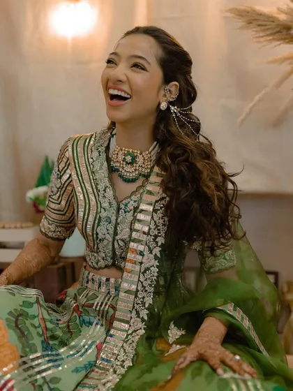 A happy, laughing bride, her hair styled in a beautiful half-updo with curls.