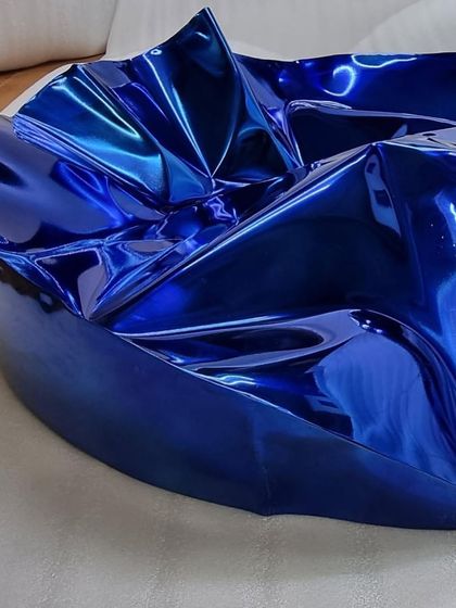 A client's home featuring a circular blue Meteor sculpture. The piece's vibrant color and texture provide a stunning contrast to the neutral tones of the living room.