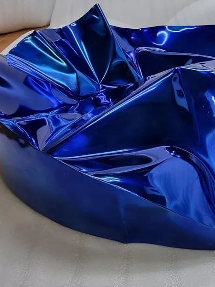 A client's home featuring a circular blue Meteor sculpture. The piece's vibrant color and texture provide a stunning contrast to the neutral tones of the living room.