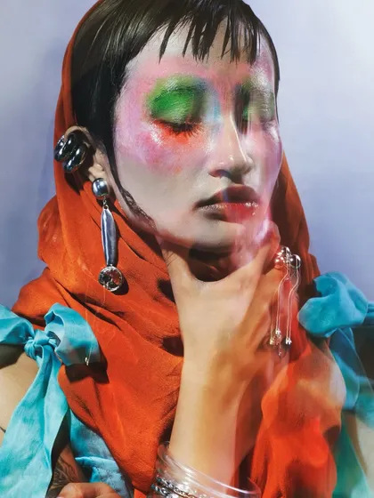 A close-up portrait highlighting the abstract makeup and the interplay of colors and textures. The motion effect adds a layer of dynamism, suggesting the constant flux of emotional states.