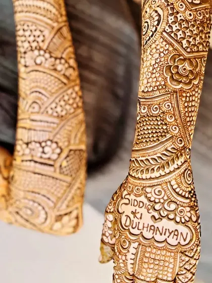 Your mehendi can include special phrases that are meaningful to you. Here, we incorporated "Siddi ki Dulhaniyan" directly into the detailed pattern on the back of the hand, making the bridal henna truly one of a kind.