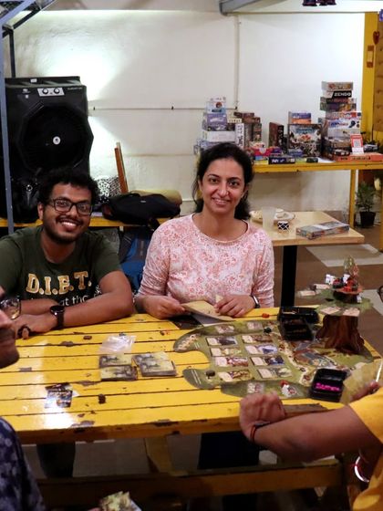 A happy group enjoying a game at our bright yellow table. The variety of games and seating options means there's something for everyone.