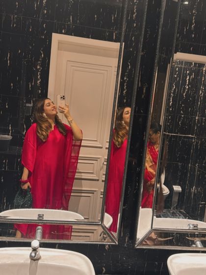 A mirror selfie capturing the elegant drape of the pink kaftan. It's a versatile piece that can be dressed up with heels and a clutch or worn casually with flats.