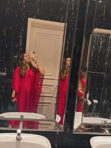 A mirror selfie capturing the elegant drape of the pink kaftan. It's a versatile piece that can be dressed up with heels and a clutch or worn casually with flats.