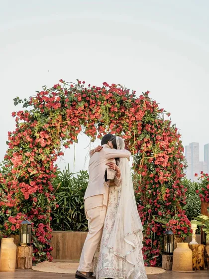 The couple shares a hug under a magnificent bougainvillea arch, which served as the ceremony backdrop and a photo point.
