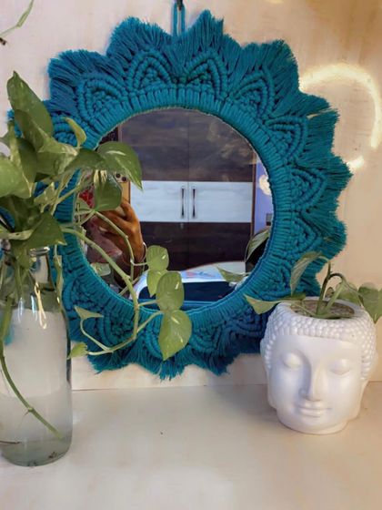Here is the teal sunburst mirror styled on a console table with plants. It functions as a beautiful decorative object that also brightens up the space.
