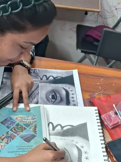An adult student in our General Art Foundation course uses a reference to practice a detailed eye drawing. We welcome learners of all ages who want to build or improve their art skills.