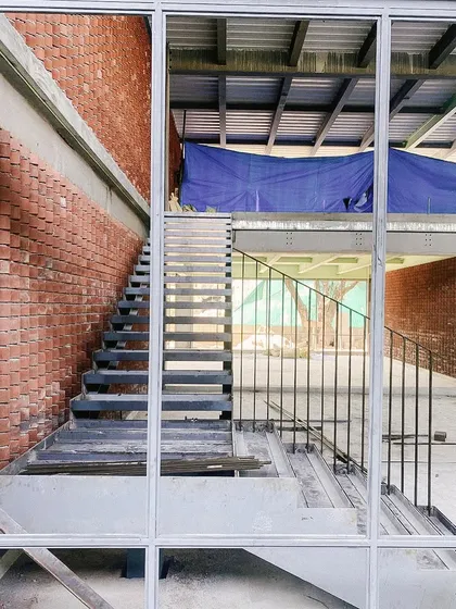 A duplicate image of the steel staircase, seen through the window framing.