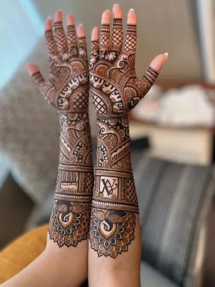 A personalized bridal design featuring the couple's initials and peacock motifs. The peacock feathers wrap around the wrist, creating a beautiful and unique cuff.