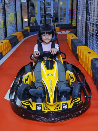 A confident young driver ready for his turn on the track. Our go-karts are a safe way for kids to feel a sense of independence.