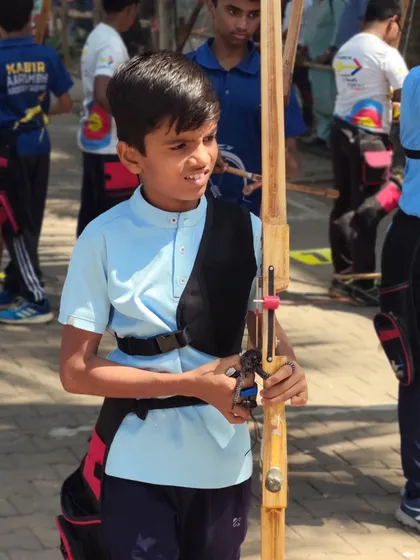 A young archer with his bow, ready for the competition. We aim to build a strong and confident next generation of athletes.