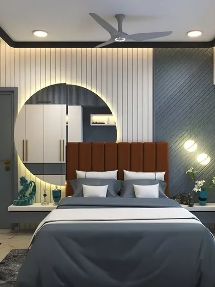 A stylish bedroom with a large, backlit circular mirror as a focal point. The upholstered headboard and textured wall panels create a rich and inviting atmosphere.