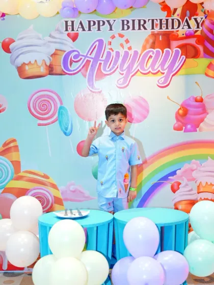 The birthday boy, Avyay, looking cool in front of his candy-themed birthday backdrop. His matching outfit completes the look for his special day.