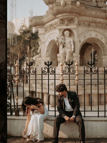 A candid moment of laughter and adjustment, showing the real, unposed side of a glamorous city photoshoot.