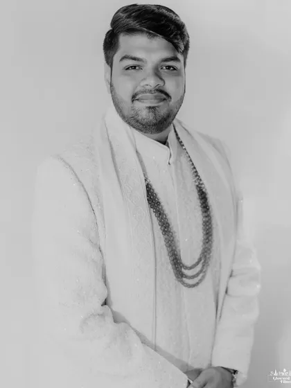A classic black and white portrait of the groom, Kavish, looking sharp and ready for his wedding at Della Resorts.