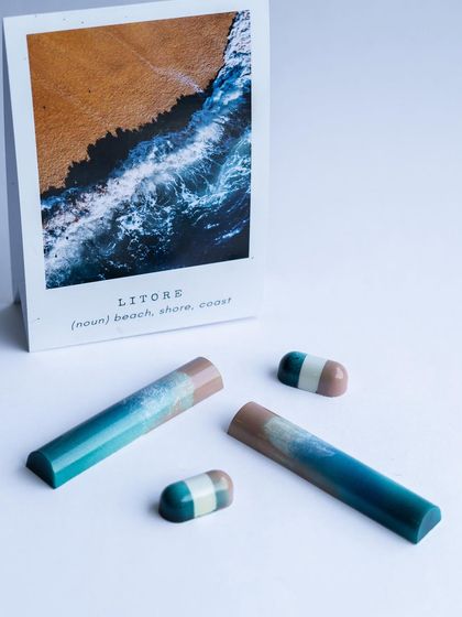 These "Litore" bonbons evoke the image of a beach meeting the coast, using layered colors to create a beautiful, serene landscape on a tiny canvas.
