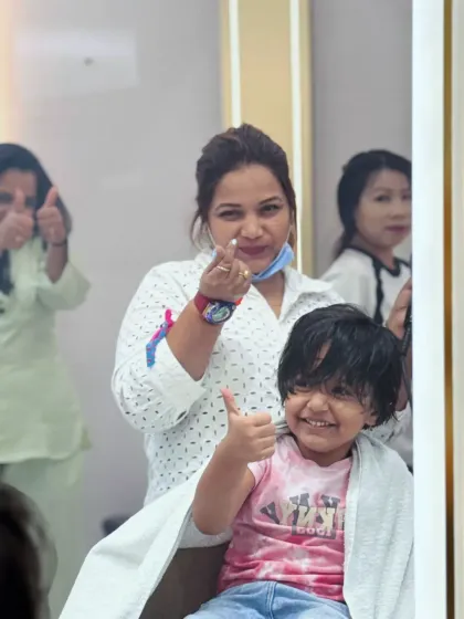 Thumbs up for a great haircut. This little one and her stylist are both happy with the result.