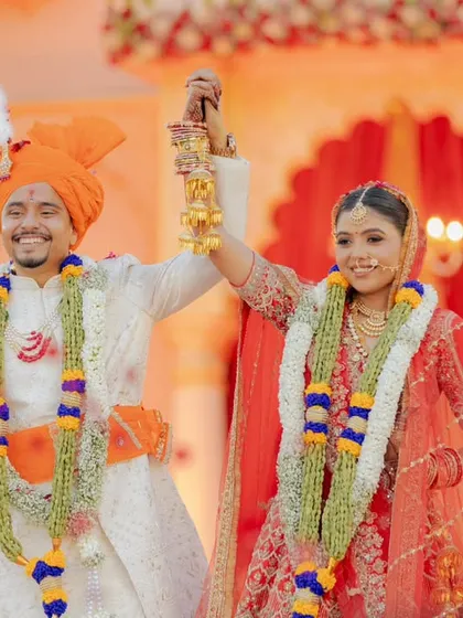 The triumphant moment after the varmala exchange. The couple's happy smiles and raised hands show their excitement for their new beginning.