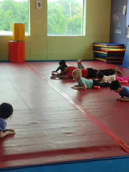 Time for a cool-down. Children lie on the mat, practicing a relaxation pose that helps them wind down after an energetic class.