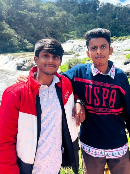 Two friends posing in front of Pykara falls. Our trips are great for creating memories with your buddies.