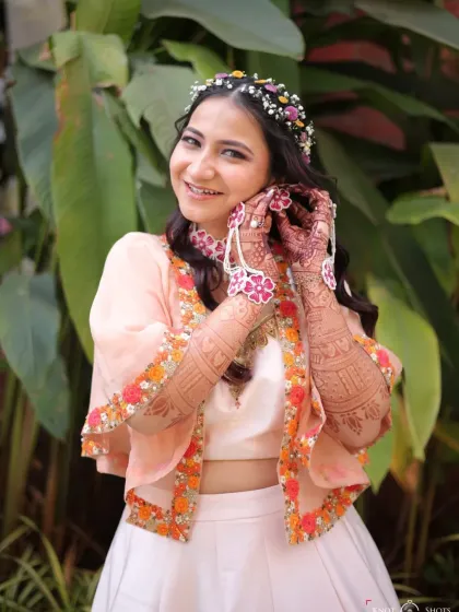 A close-up showing the delicate floral jewelry and the fresh, dewy makeup. The look is perfect for a vibrant, outdoor Haldi event.