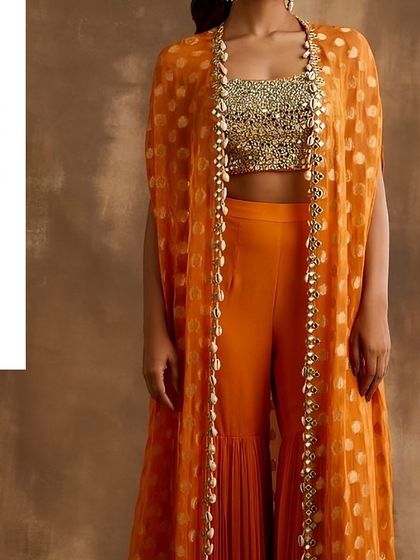 Brighten up any event with this vibrant orange palazzo set. The sequined gold bustier is perfectly complemented by a lightweight, polka-dotted shrug, making it a fun and festive choice.