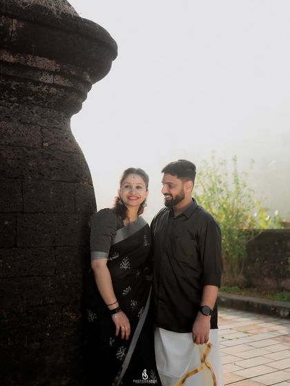 A classic couple portrait against the textured wall of the fort. The soft, hazy light adds a moody and romantic atmosphere.