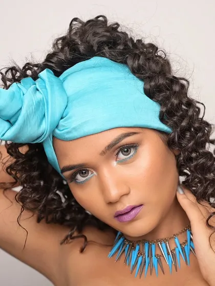 This pose highlights the volume and texture of the curly hair.