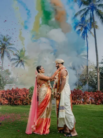 A modern and creative Varmaala moment. We love incorporating unique elements like colored smoke to add a dynamic and artistic flair to traditional wedding rituals, making your film visually unforgettable.