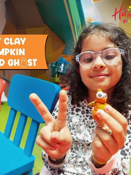 A proud girl shows off the DIY clay pumpkin and ghost she made. Our Halloween workshops are all about hands-on, creative fun that isn't too scary for the little ones.