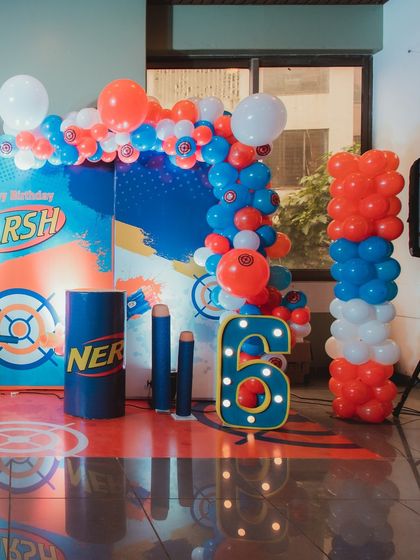 A detailed look at the Nerf Gun party decor, showing the custom backdrop with the birthday boy's name, "DARSH", and the light-up number '6'.