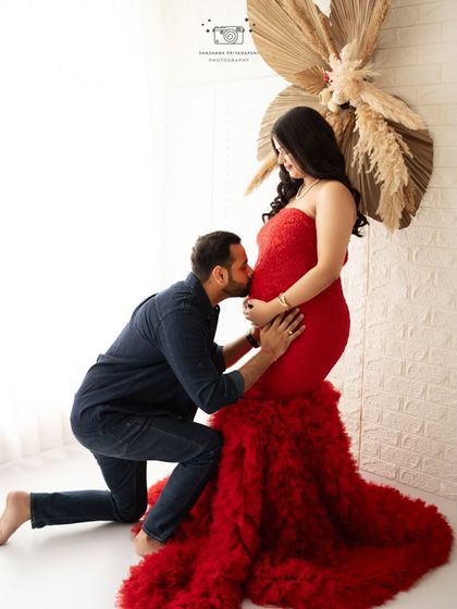 A kiss for the baby. This kneeling pose is full of love and tenderness, beautifully captured in our professional photography studio.