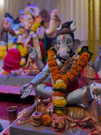 Another angle showing the idols at the Gokul Nagari pandal, highlighting the seating arrangement and the depth of the setup.