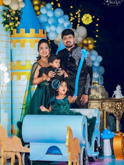 The birthday twins enjoying a ride in a blue carriage prop at their royal party.
