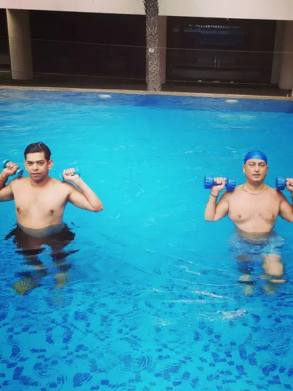 My aqua aerobics classes are for everyone. Here, two members are performing bicep curls with water dumbbells, an effective way to build upper body strength.